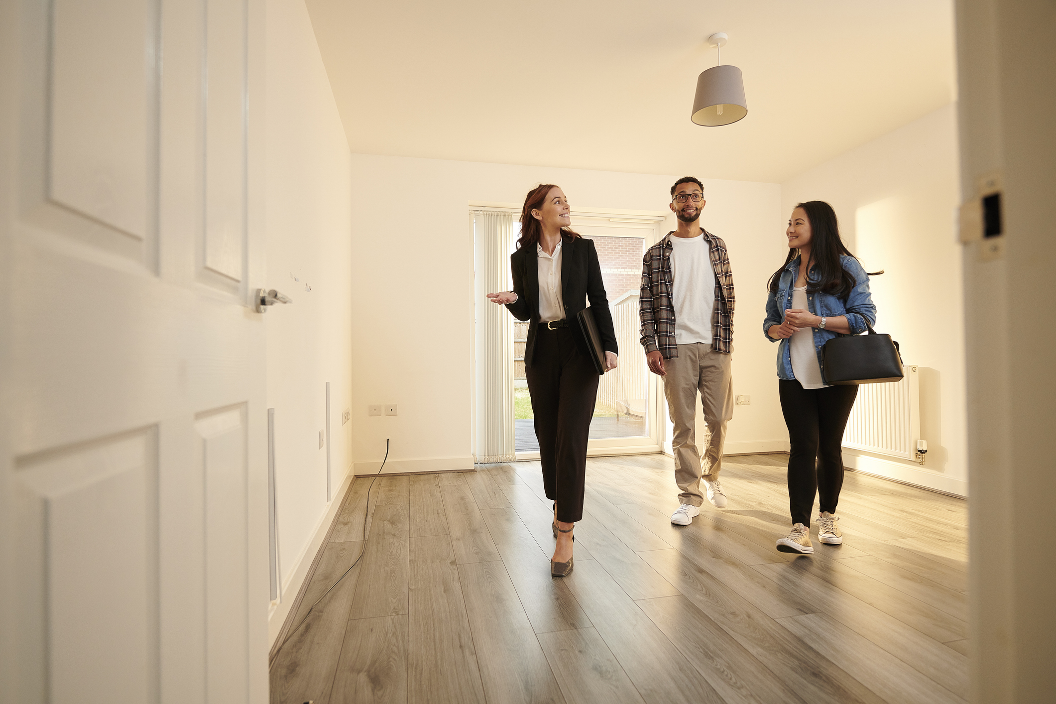 real estate agent showing a couple a new home